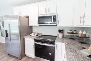 Granite kitchen countertops, stove, oven, microwave, and refrigerator.