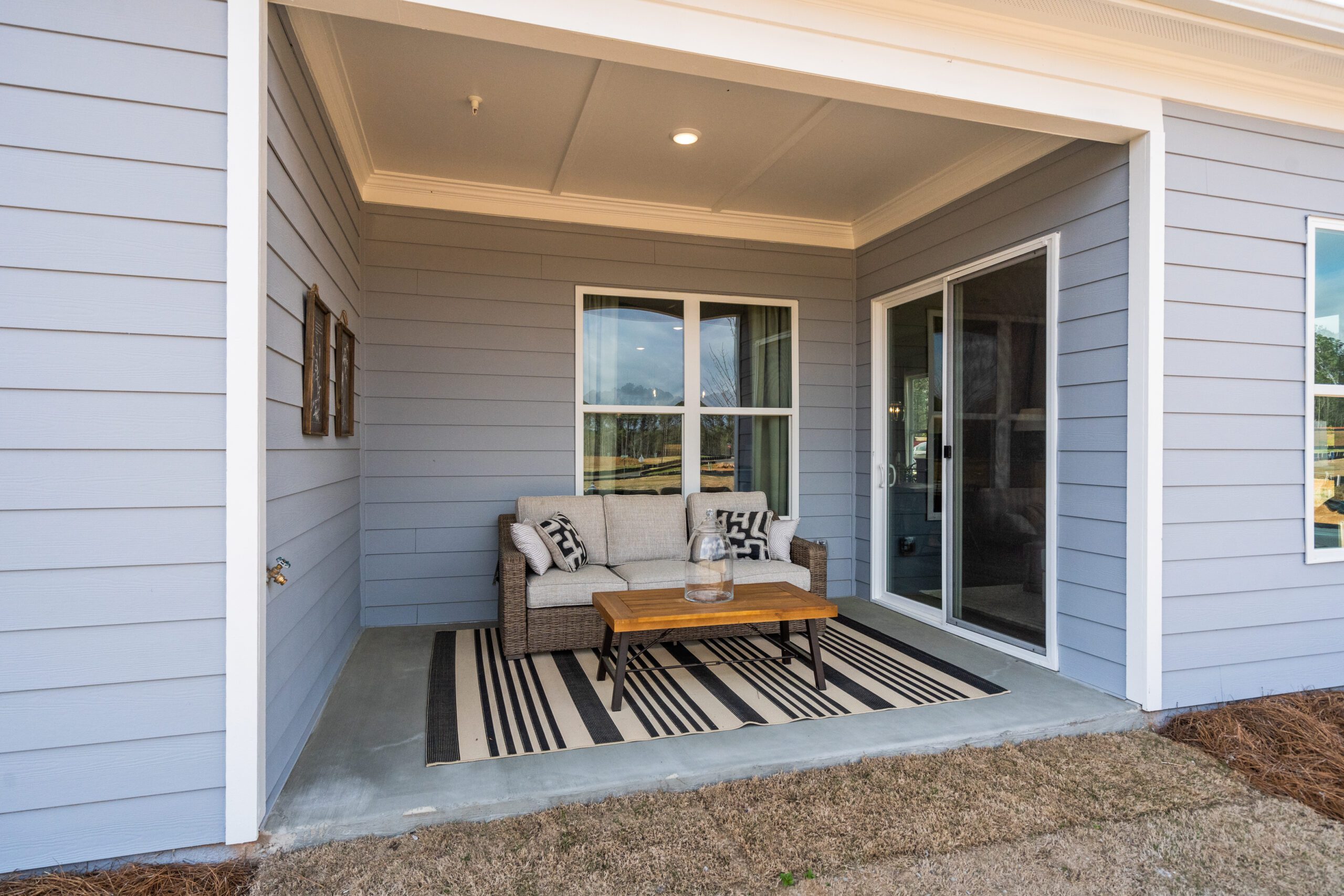 An outdoor seating area with sliding glass door and walls surrounding three sides.